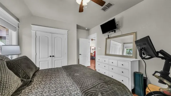 a bedroom with a bed and a flat tv screen on dresser
