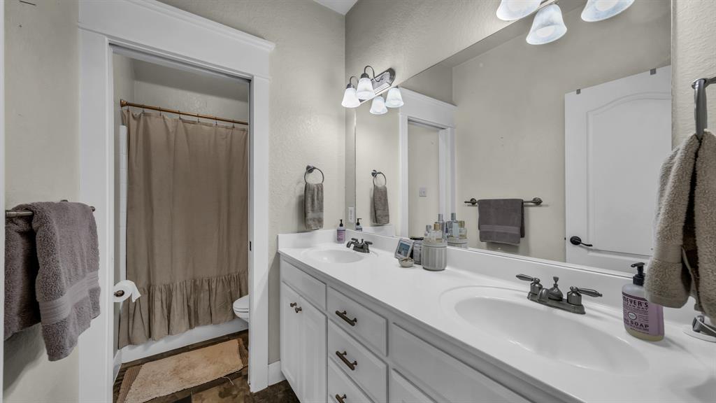 2691 Farm To Market Road 730 North Decatur, TX 76234 - Photo 22 of 36 a bathroom with double vanity sinks a vanity a lamp and a mirror