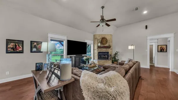 a living room with furniture a flat screen tv and a fireplace