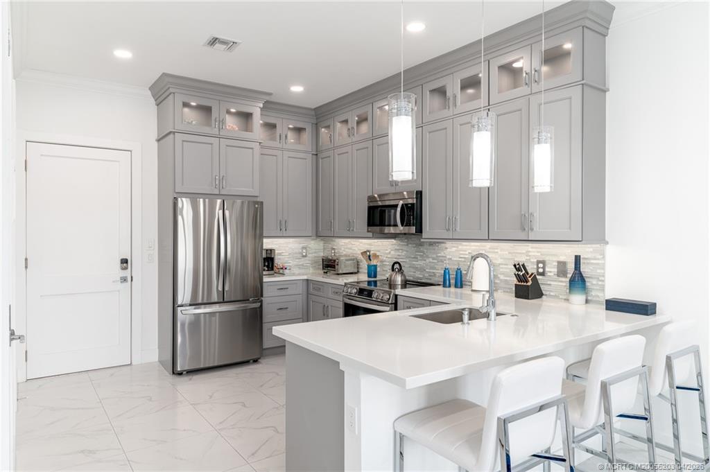 4683 Southeast Manatee Terrace Stuart, FL 34997 - Photo 21 of 45 a kitchen with stainless steel appliances a refrigerator sink and microwave