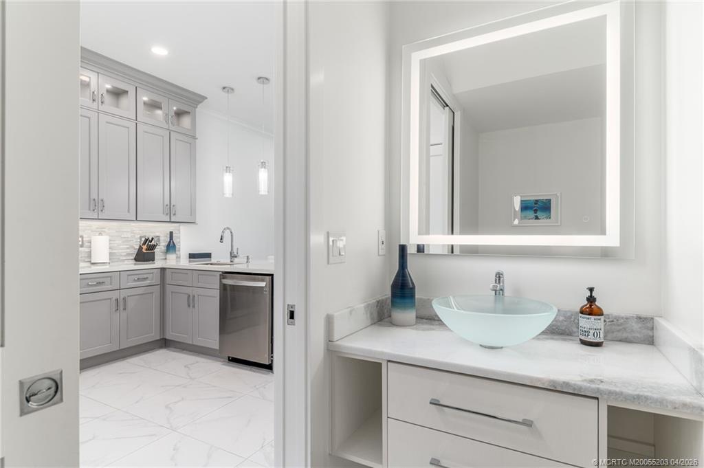 4683 Southeast Manatee Terrace Stuart, FL 34997 - Photo 24 of 45 a bathroom with a granite countertop sink and a mirror