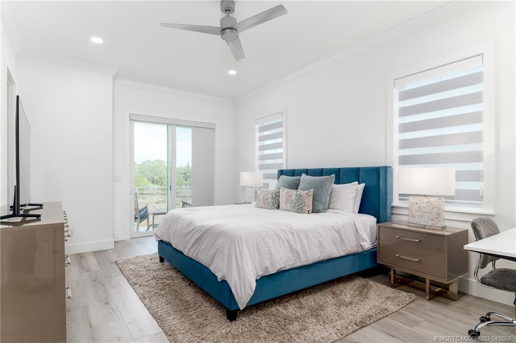 4683 Southeast Manatee Terrace Stuart, FL 34997 - Photo 26 of 45 a bedroom with a bed and large windows