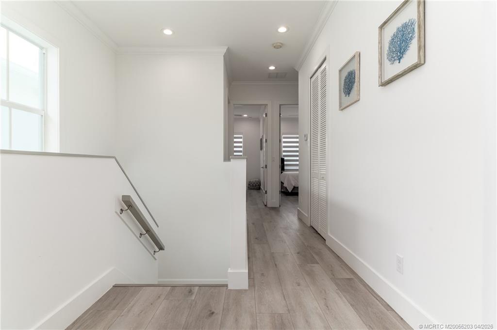 4683 Southeast Manatee Terrace Stuart, FL 34997 - Photo 31 of 45 a view of a hallway with wooden floor and staircase