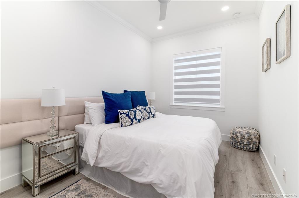 4683 Southeast Manatee Terrace Stuart, FL 34997 - Photo 32 of 45 a bedroom with a bed and a night stand
