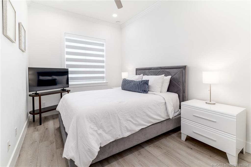 4683 Southeast Manatee Terrace Stuart, FL 34997 - Photo 33 of 45 a bedroom with a bed table and a lamp