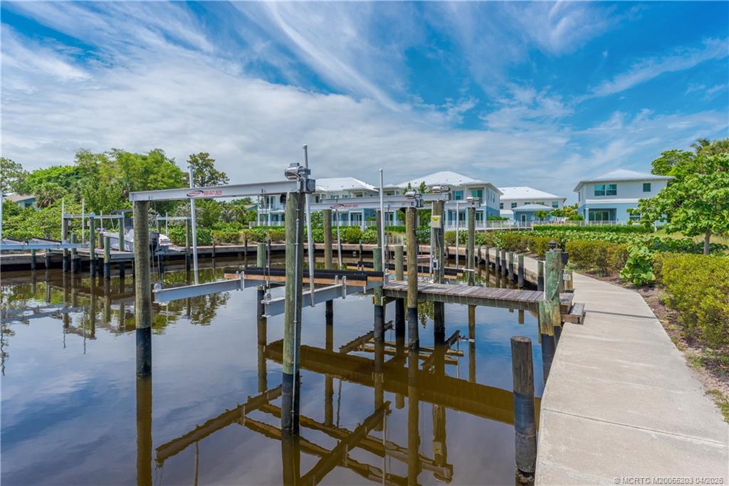 4683 Southeast Manatee Terrace Stuart, FL 34997 - Photo 5 of 45 a view of a lake with a table and chairs