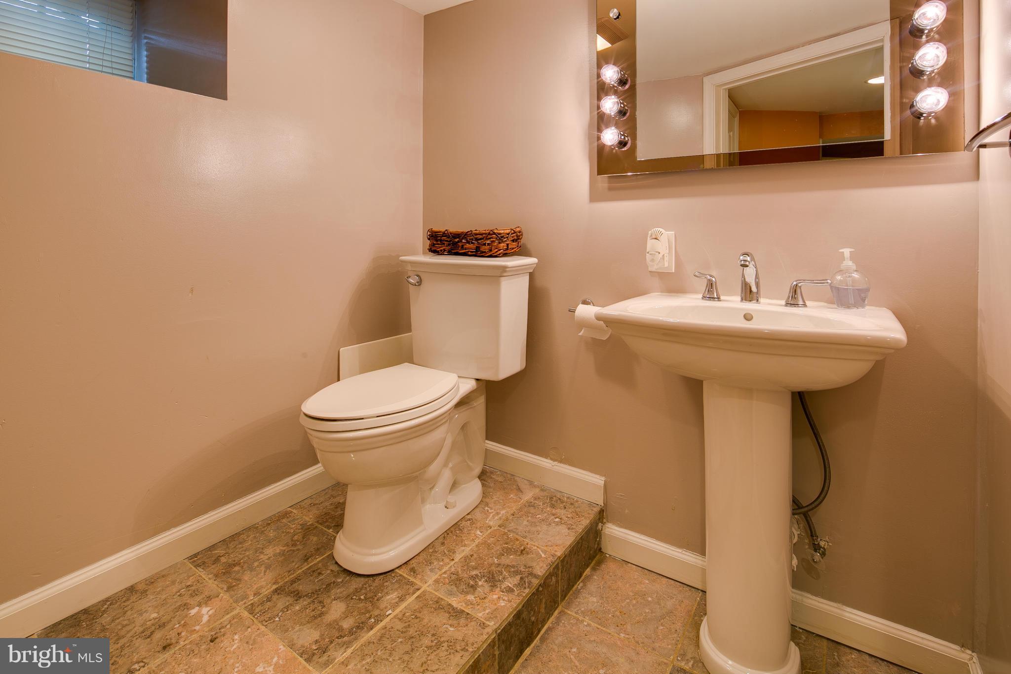 5001 Levindale Road Baltimore, MD 21215 - Photo 14 of 20 a bathroom with a sink toilet and a mirror