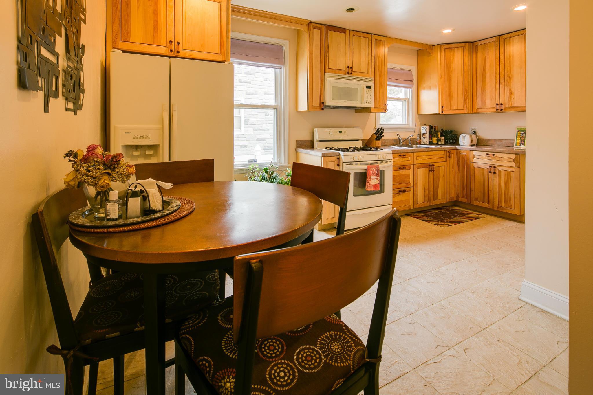 5001 Levindale Road Baltimore, MD 21215 - Photo 8 of 20 a kitchen with stainless steel appliances granite countertop a sink a stove a table and chairs