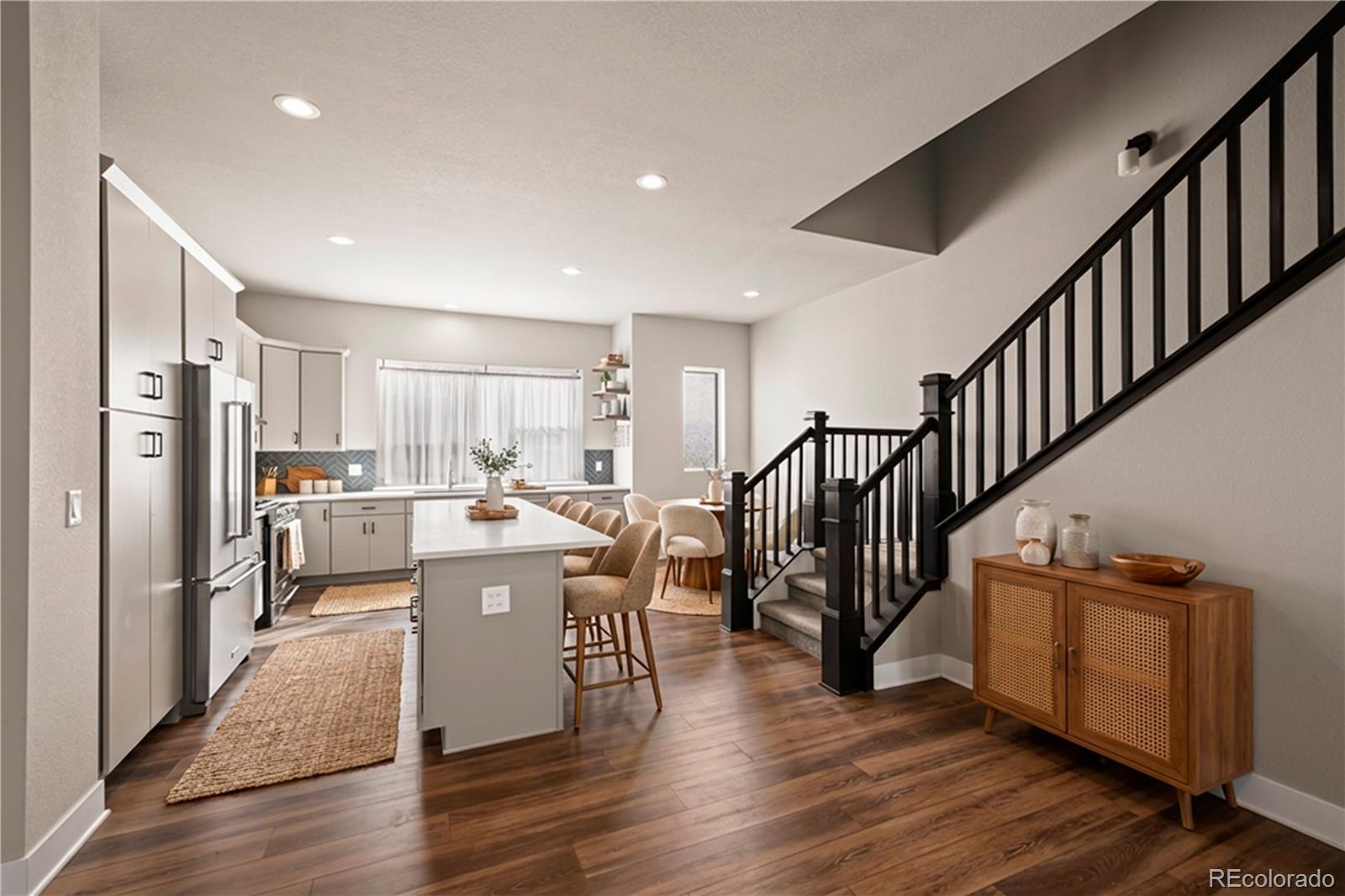 a view of a kitchen with kitchen island wooden floors stainless steel appliances and a window