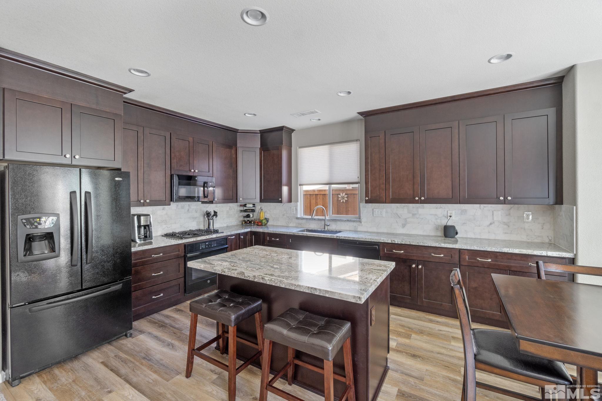 420 Stradella Court Reno, NV 89521 - Photo 6 of 40 a kitchen with granite countertop a sink counter space stainless steel appliances and cabinets
