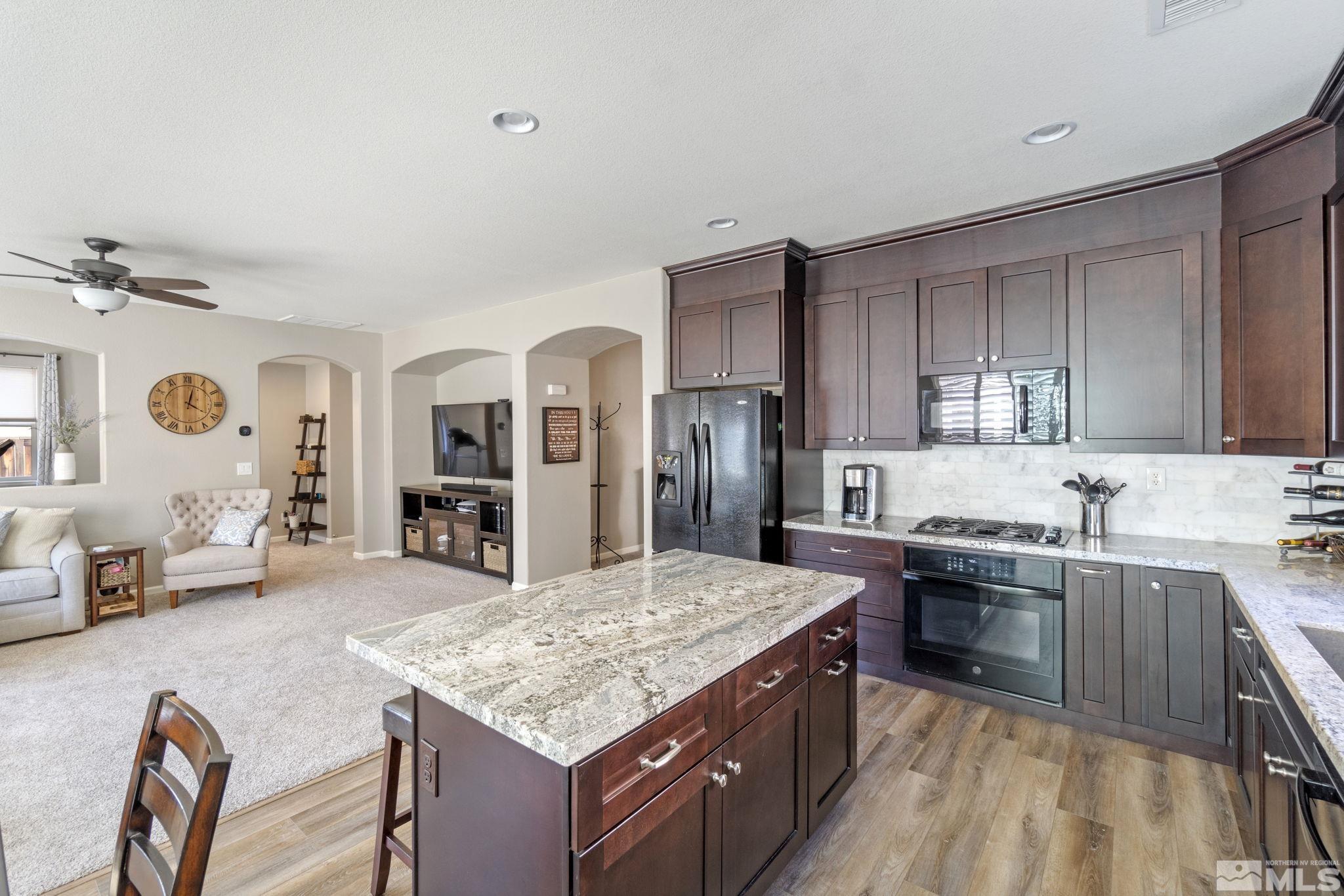 420 Stradella Court Reno, NV 89521 - Photo 7 of 40 a kitchen with stainless steel appliances granite countertop a sink stove and refrigerator