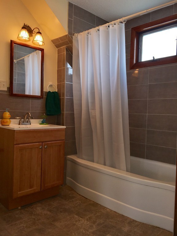 11 Bushwick Place Springfield, MA 01109 - Photo 8 of 13 a bathroom with a sink a mirror and a bathtub