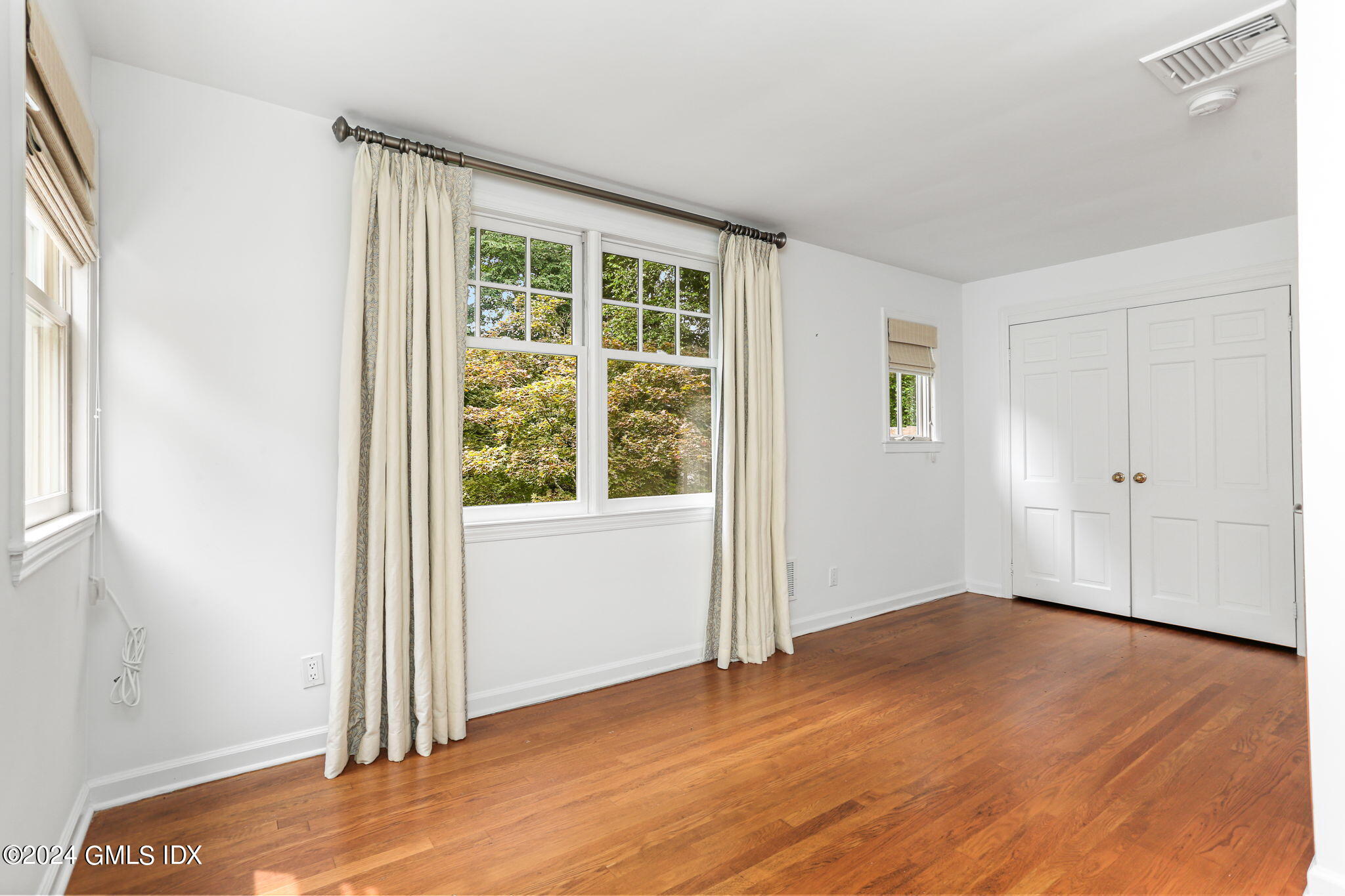 306 Stanwich Road Greenwich, CT 06830 - Photo 73 of 87 an empty room with wooden floor and windows