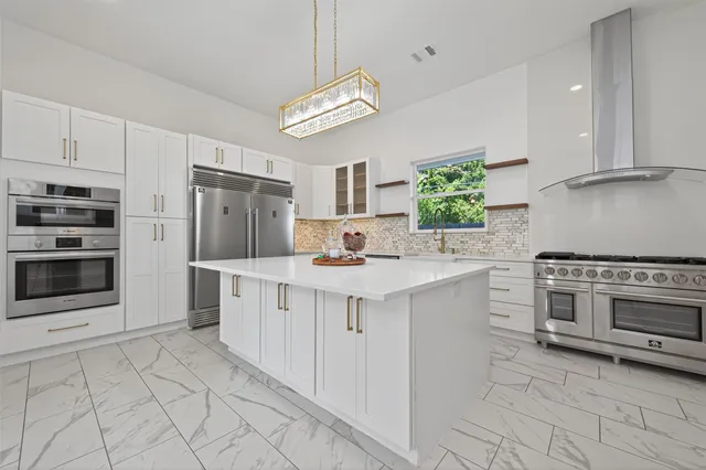 a kitchen with cabinets a stove and a wooden floor