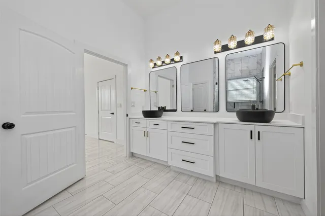 a spacious bedroom with a bed and dresser