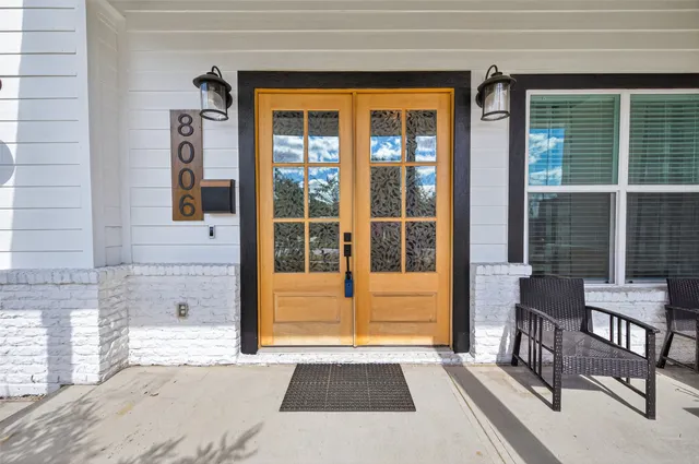 a living room filled with furniture and large windows