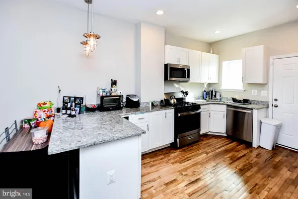 a kitchen with a sink a counter top space appliances and cabinets