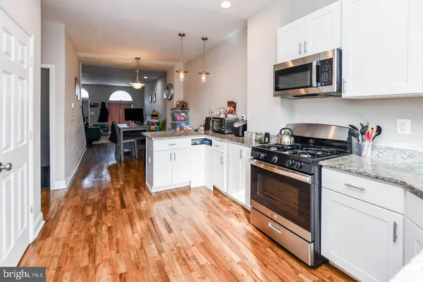 a kitchen with a stove a sink and a microwave