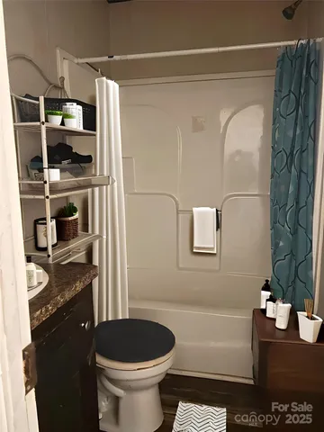a bathroom with a granite countertop sink a toilet and shower