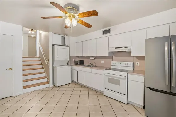 a kitchen with white cabinets and white appliances