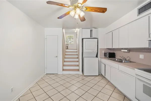 a kitchen with a sink stainless steel appliances a refrigerator and cabinets