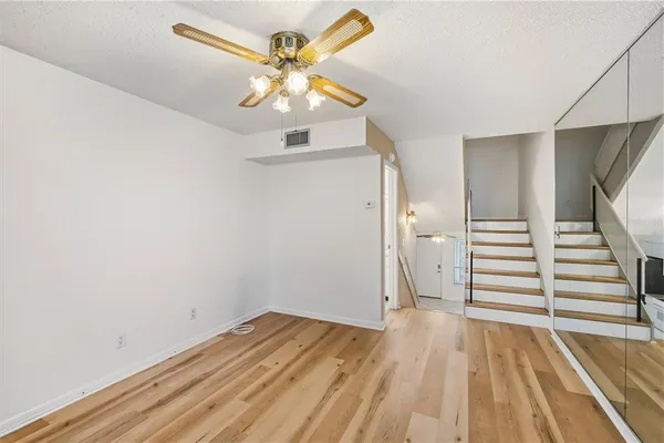wooden floor in an empty room with a chandelier
