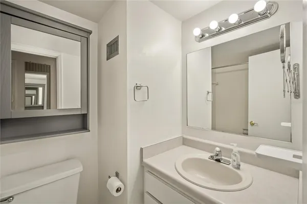a bathroom with a sink a toilet and a mirror