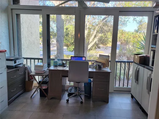 a view of a workspace with furniture and a window