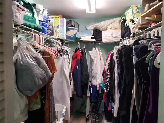a view of walk in closet with clothes