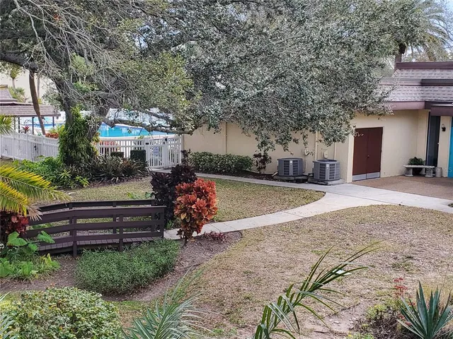 a view of a house with a yard and potted plants
