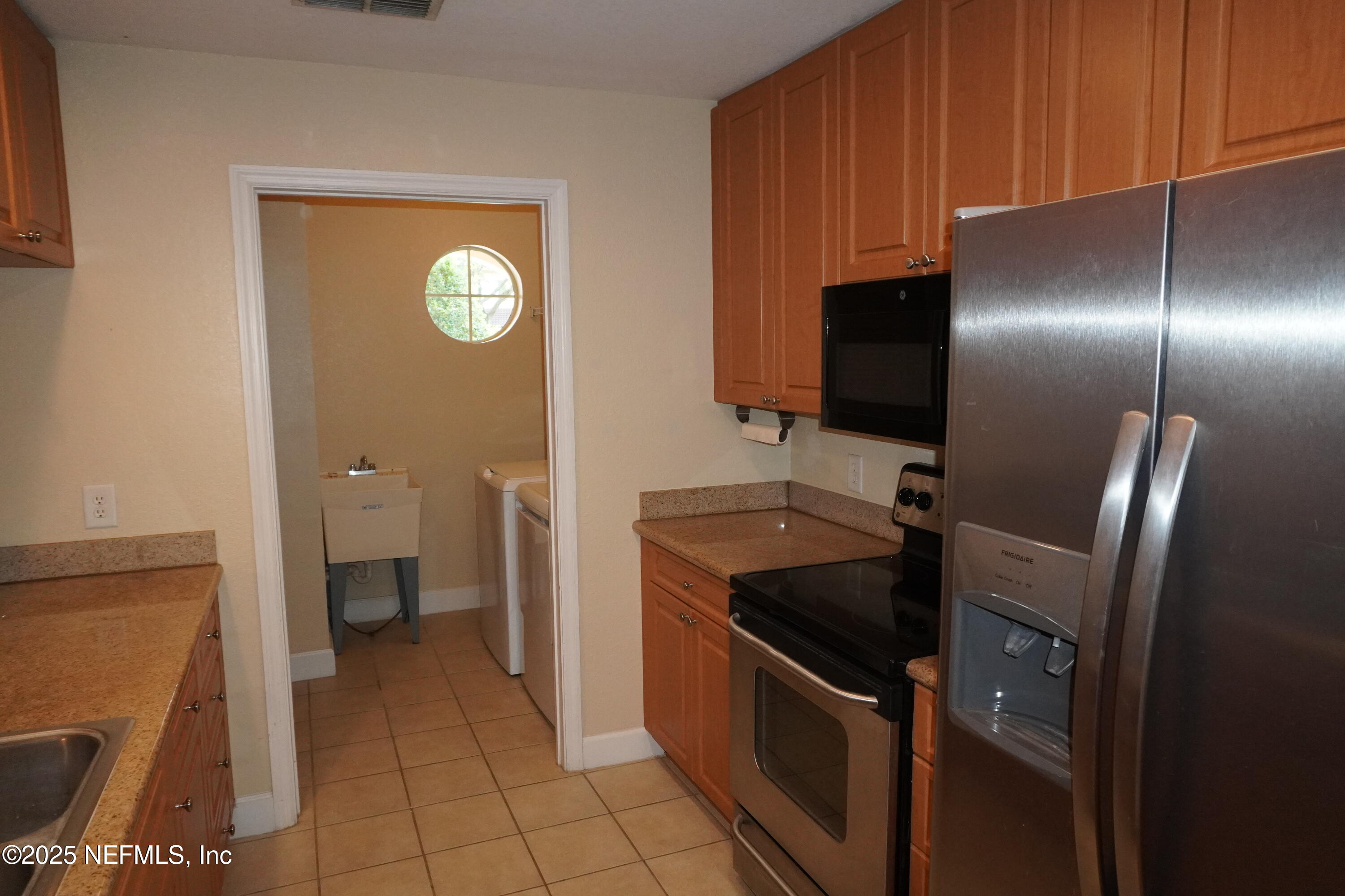 9745 Touchton Road, Unit 2201 Jacksonville, FL 32246 - Photo 10 of 32 a kitchen with stainless steel appliances granite countertop a refrigerator and a sink