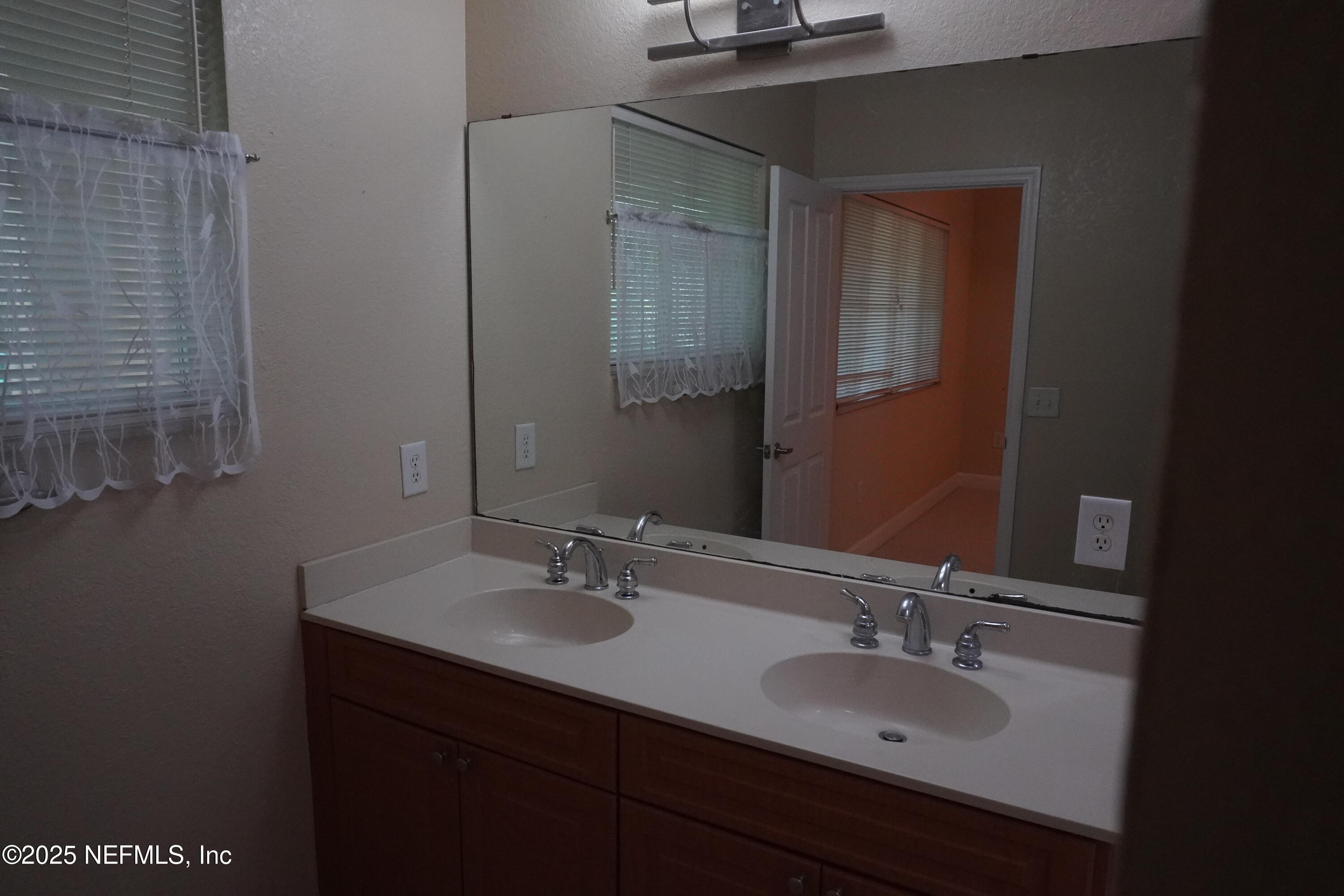 9745 Touchton Road, Unit 2201 Jacksonville, FL 32246 - Photo 18 of 32 a bathroom with a sink and a mirror
