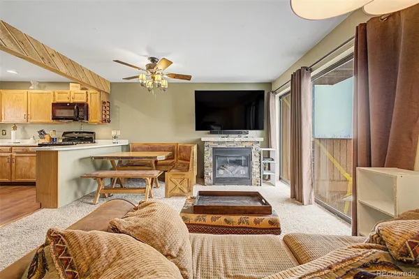 a living room with furniture a flat screen tv and a fireplace