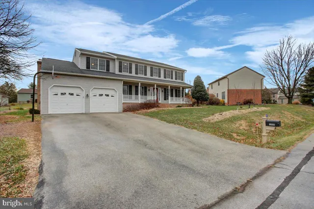 a view of residential houses with yard and road