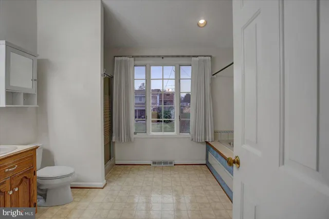 an empty room with closet and a chandelier fan