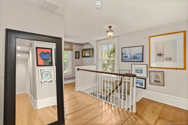 a view of a hallway with wooden floor and windows