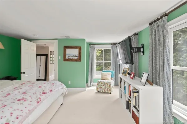 a bedroom with a bed couch and a window