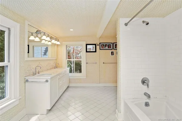 a spacious bathroom with a bathtub sink and mirror