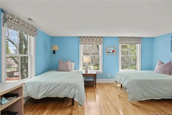 a bedroom with a large bed and wooden floor