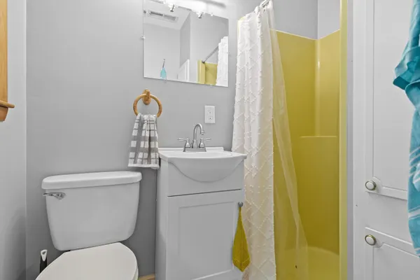 a bathroom with a toilet sink vanity and mirror