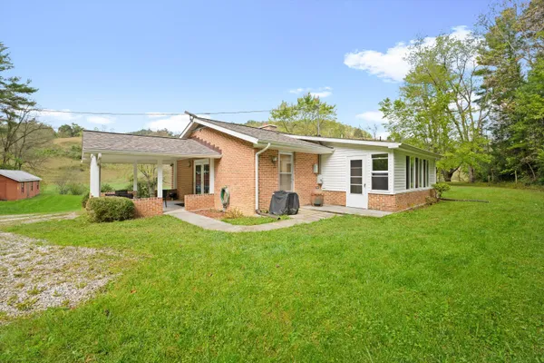 a view of a house with a backyard and a patio