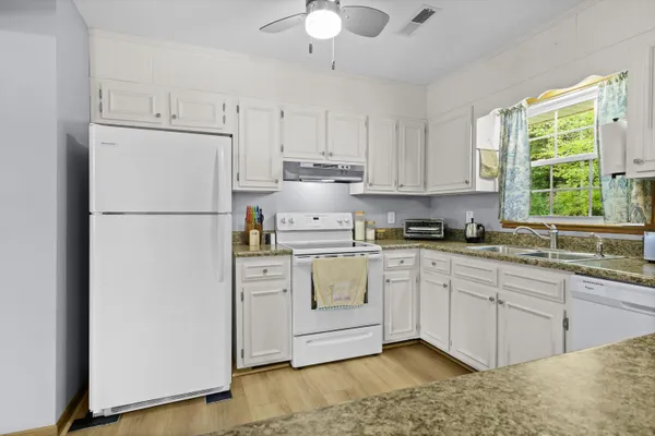 a kitchen with appliances a sink and a window