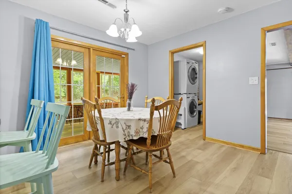a view of a dining room with furniture wooden floor and chandelier