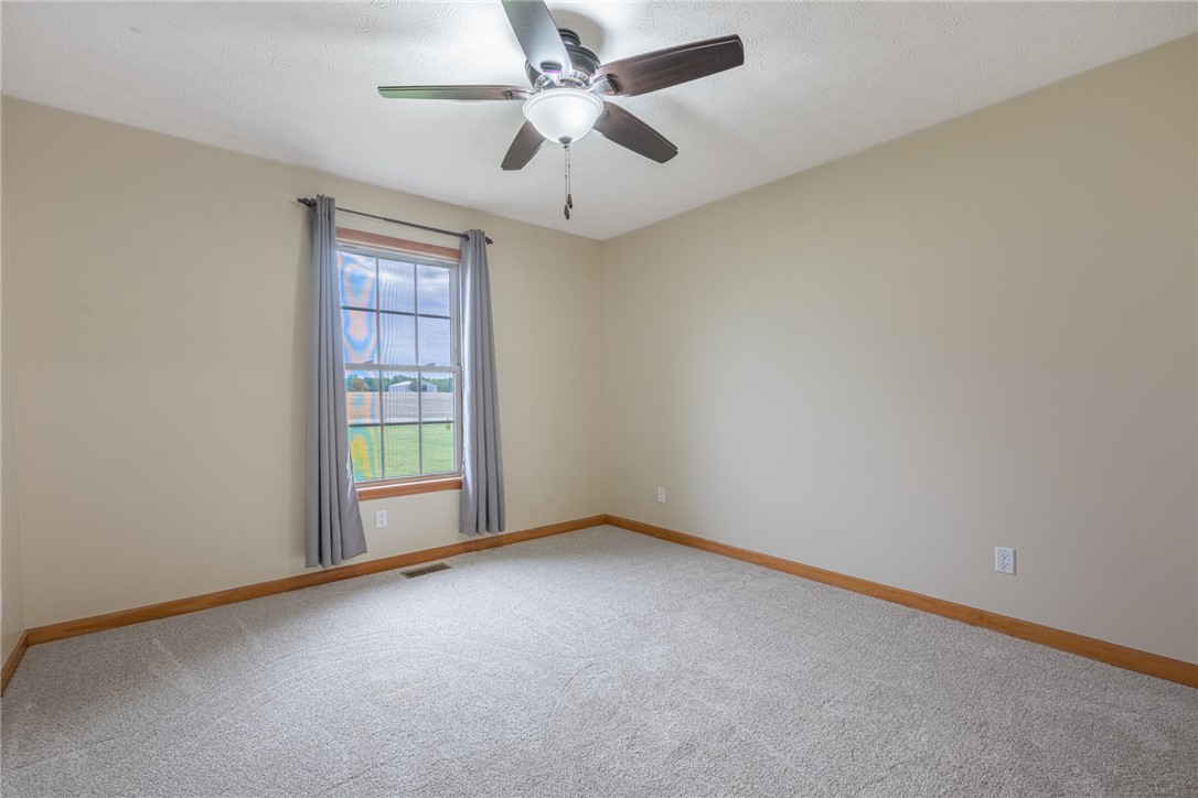 2645 Vance Road St. Paris, OH 43072 - Photo 17 of 35 An airy bedroom with a window offers serene views and soft carpeting underfoot.