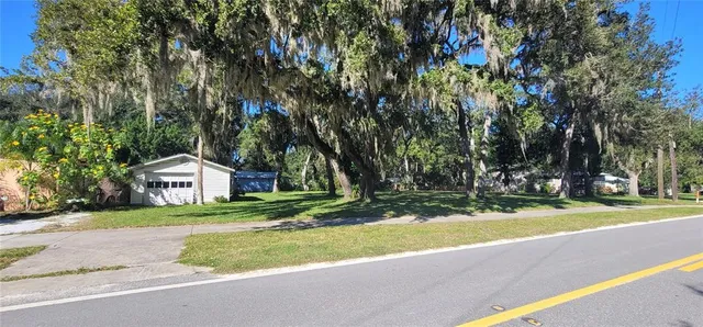 a front view of a house with a yard and trees