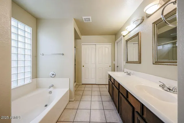 a bathroom with a tub sink and mirror