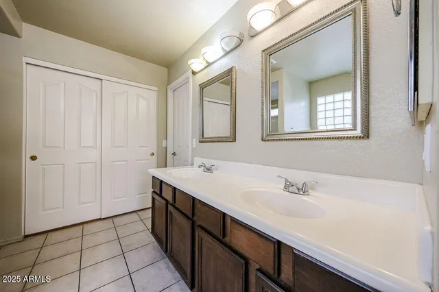 a spacious bathroom with a double vanity sink a mirror and a shower