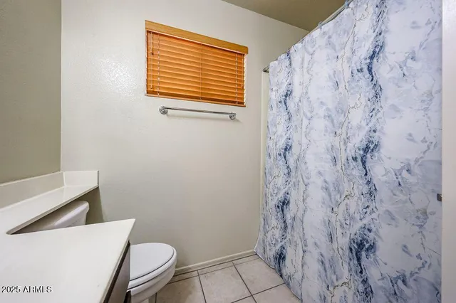 a bathroom with a toilet and a shower curtain