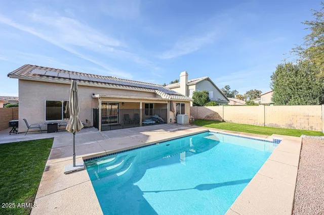 a view of a house with swimming pool and sitting area