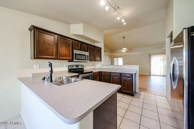 a kitchen with stainless steel appliances a refrigerator sink stove microwave and cabinets